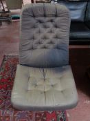 A mid century swivel cloth buttoned chair