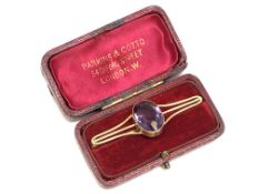 An antique gold brooch set with a large amethyst