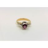 An 18ct yellow gold diamond set ring, the central stone possibly garnet, size O/P.