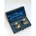 A boxed pair of ornate silver napkin rings