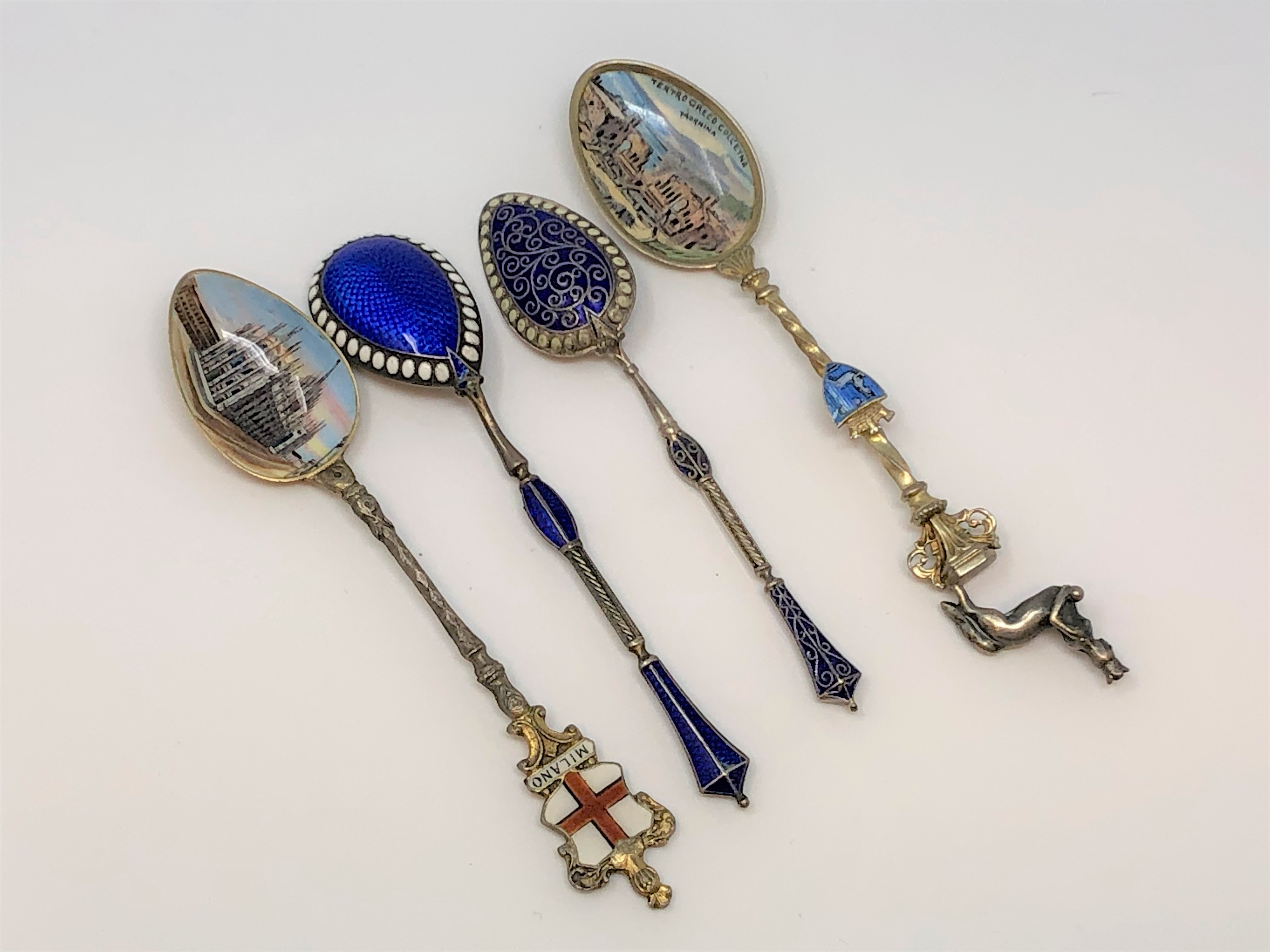 Four ornate silver and enamel spoons.