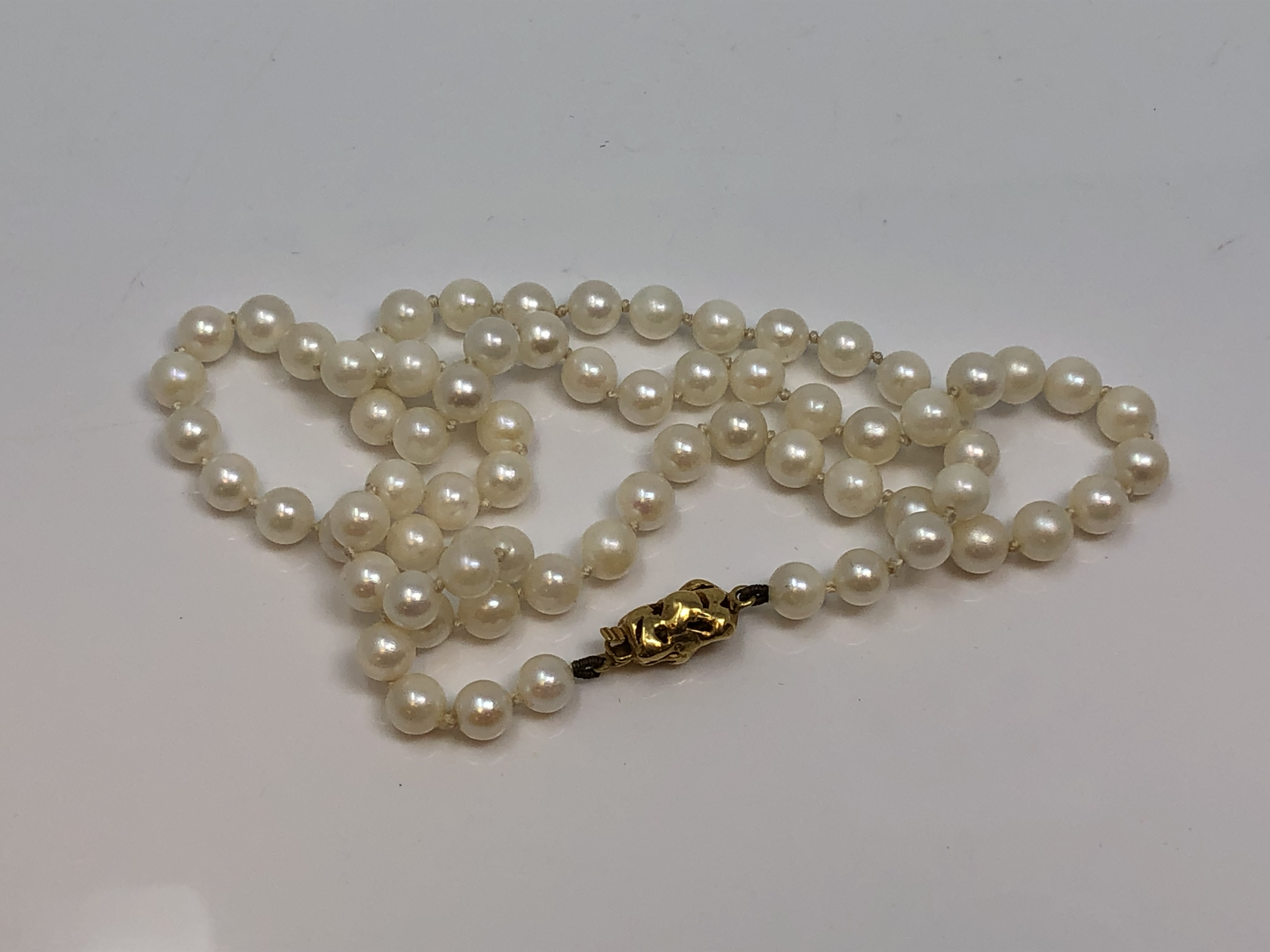 A 20 inch strand of pearls of 18ct gold clasp