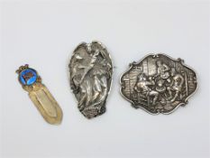 Two large ornate silver brooches and silver gilt clip.