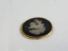 An antique Wedgwood brooch in yellow gold frame