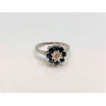 An 18ct white gold diamond and sapphire cluster ring, the central stone approximately 0.3ct, size M.