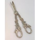 A very ornate pair of silver grape scissors depicting foxes.