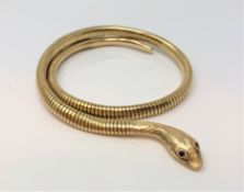 A 9ct gold snake bangle with ruby set eyes CONDITION REPORT: 29.