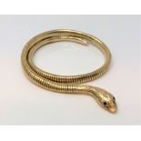 A 9ct gold snake bangle with ruby set eyes CONDITION REPORT: 29.