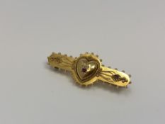 A 15ct gold brooch with central heart set with ruby and diamond CONDITION REPORT: 4.