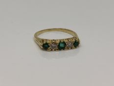 An 18ct gold five stone emerald and diamond ring, size P CONDITION REPORT: 3.