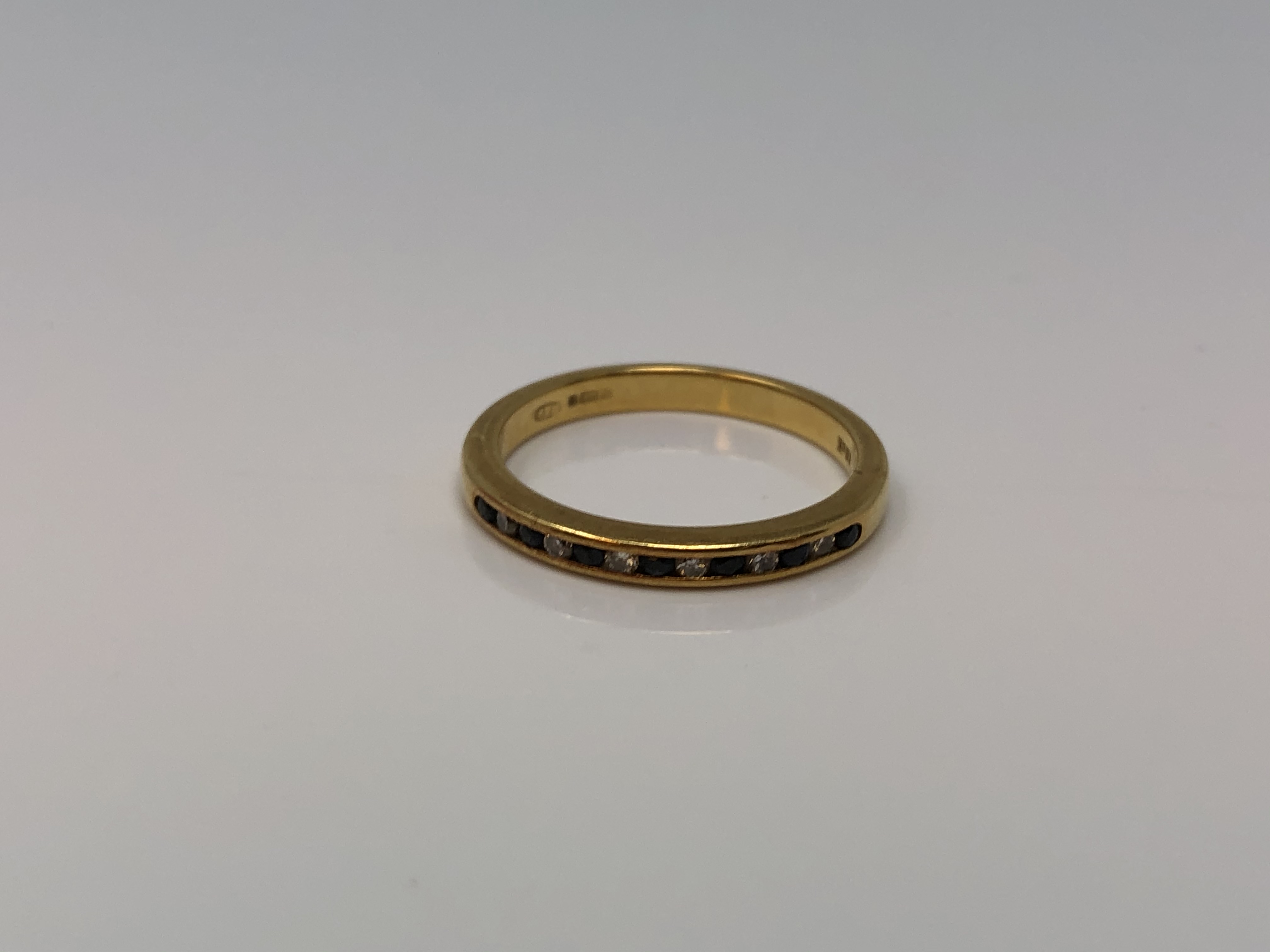 An 18ct gold sapphire and diamond half eternity ring, size N CONDITION REPORT: 2.