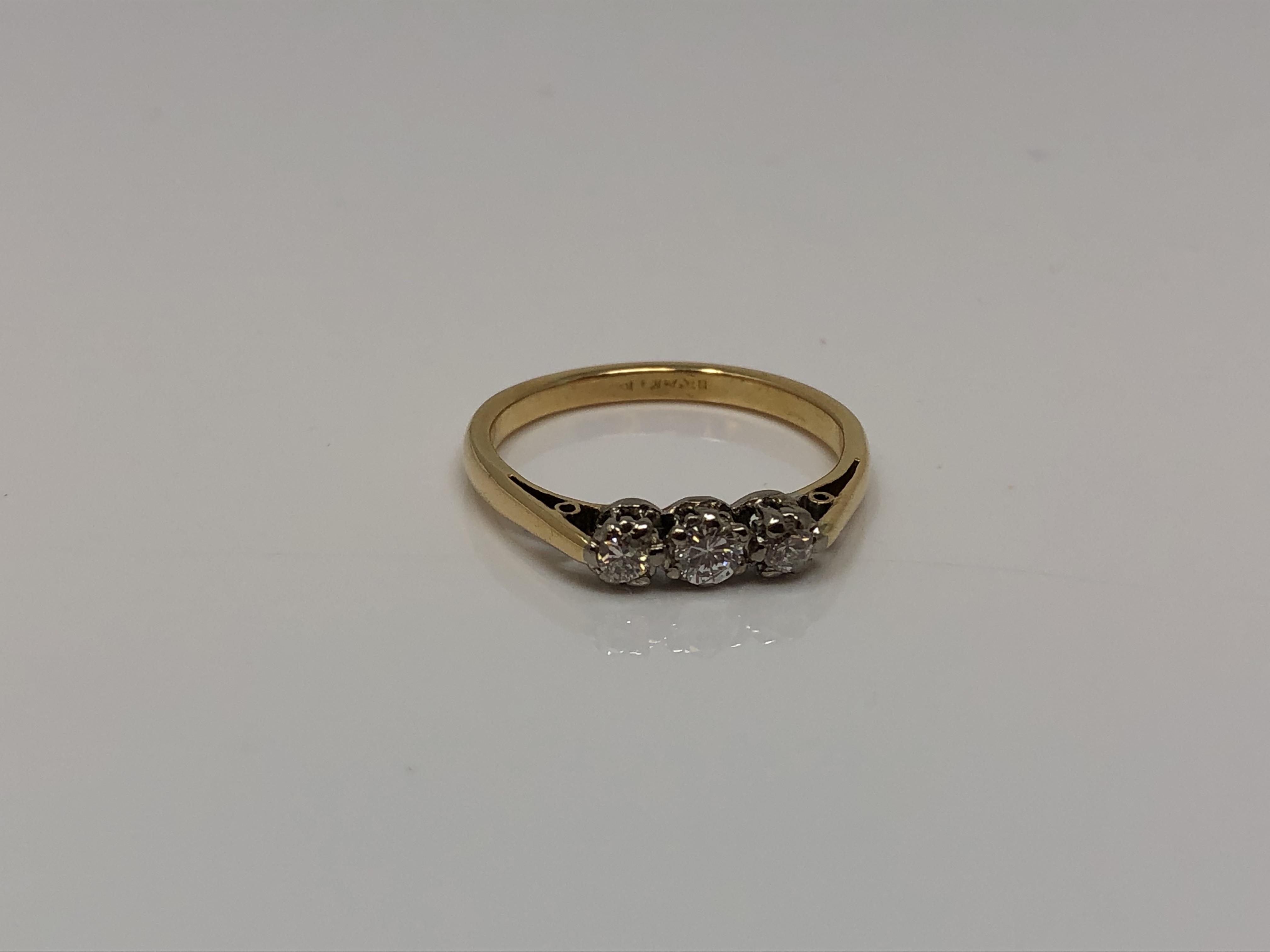 An 18ct gold three stone diamond ring, size L CONDITION REPORT: 2.