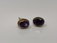 A pair of 9ct gold oval cut amethyst earrings with post fittings.