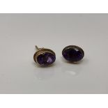 A pair of 9ct gold oval cut amethyst earrings with post fittings.