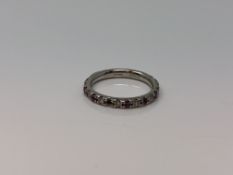 A platinum ruby and diamond half eternity ring,