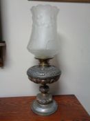 A Victorian metal oil lamp with glass shade