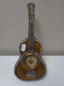 An ornate white metal table barometer in the form of a guitar