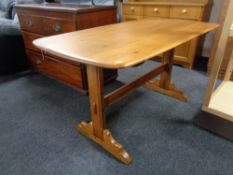 An Ercol style polished elm dining table