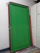 A snooker table with cues and balls