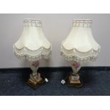 A pair of hand painted porcelain table lamps on brass bases with tasselled shades