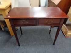 A reproduction mahogany two drawer side table