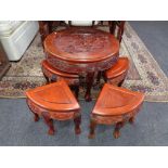 A carved Chinese occasional table fitted with nest beneath