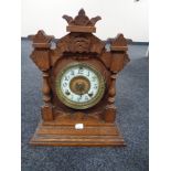 An Edwardian oak mantel clock with enamel dial by the Ansonia clock company