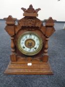 An Edwardian oak mantel clock with enamel dial by the Ansonia clock company