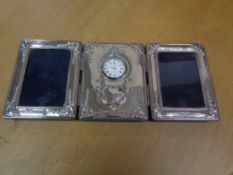 A silver framed triple photograph frame with clock central panel CONDITION REPORT: