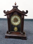 An early twentieth century stained beech alarm clock with pendulum