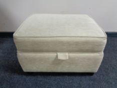 An upholstered oatmeal fabric storage stool