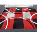 A contemporary machine made carpet with red and black design