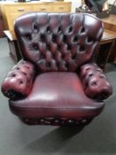 A Burgundy leather Chesterfield style armchair