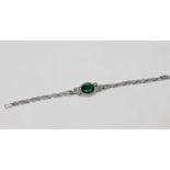 A 14ct white gold emerald and diamond bracelet, the oval-cut emerald weighing approximately 3.