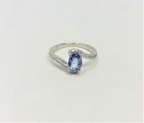 A 14ct white gold sapphire and diamond ring featuring centre oval cut blue sapphire (1.