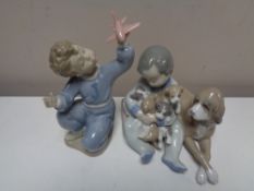 A Lladro figure - Child holding dogs together with a Nao figure of a child with aeroplane (2)