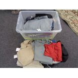 A crate of new and un-used clothing, trousers,