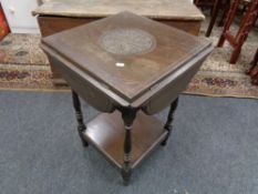 An Edwardian oak flap sided table