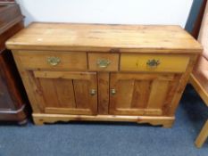 An antique pine sideboard fitted with three drawers, height 80 cm, width 127 cm and depth 44 cm.