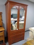 A contemporary mirror door wardrobe fitted with three drawers