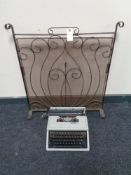 An Olivetti typewriter together with a metal fire screen