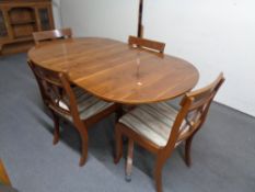 An inlaid yewwood oval dining table together with four chairs