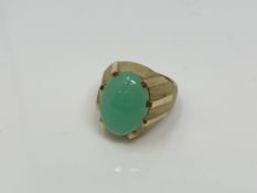 A continental yellow gold ring, the textured shank set with a cabochon apple green jade stone,