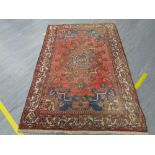 An Iranian wool carpet on red ground 137 cm x 210 cm