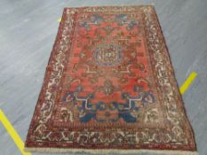 An Iranian wool carpet on red ground 137 cm x 210 cm