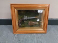 A montage in glazed box frame : Ornamental flintlock pistol with brass and copper powder flask,