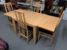 A contemporary beech extending dining table and four chairs