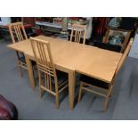 A contemporary beech extending dining table and four chairs