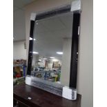 A contemporary all glass mirror in black frame