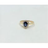 A 14ct yellow gold sapphire and diamond ring featuring centre pear cut blue sapphire (1.